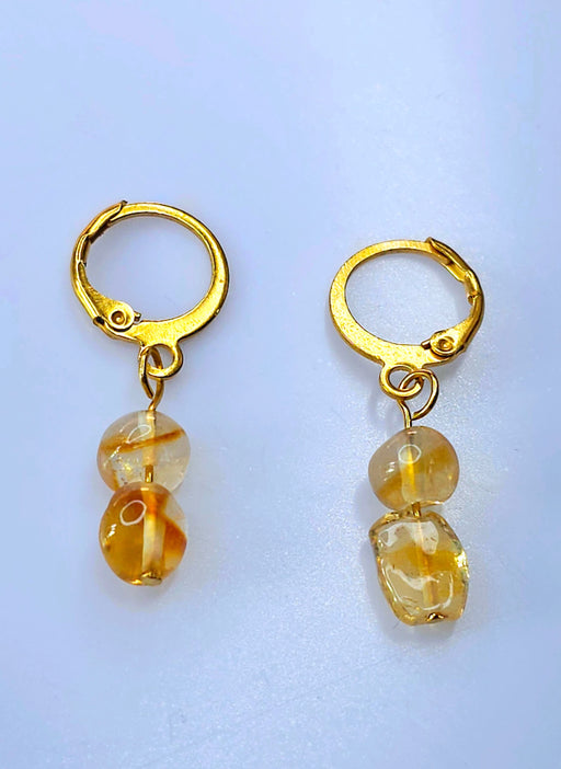 An image showcasing a pair of elegant handmade citrine birthstone hoop earrings, capturing the warm golden hues of the gemstones against a soft background, symbolizing November birthstone elegance