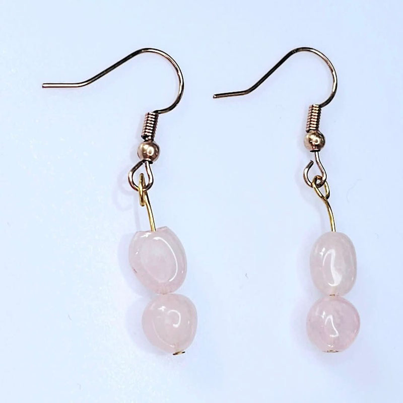 A pair of elegant handcrafted rose quartz dangle earrings, perfect for October birthdays or adding a touch of feminine charm to any outfit.
