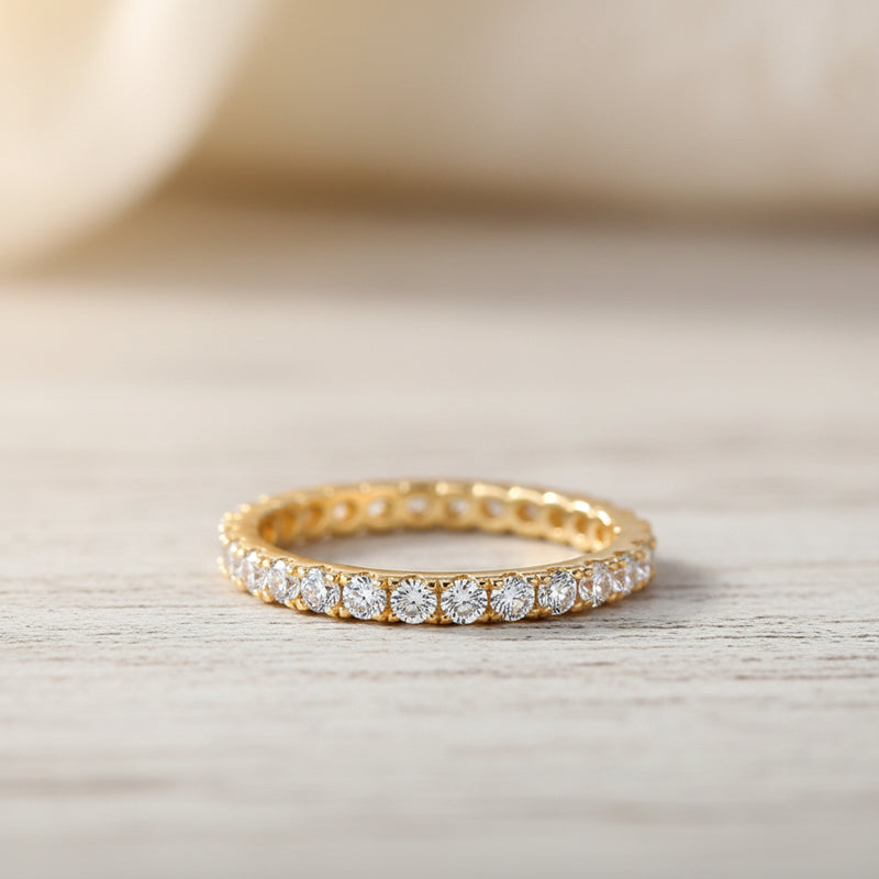 A gold eternity ring with clear round-cut gemstones, shown on a white background with promotional text including 'Adodo Ready to ship' and feature bullet points for nickel-free, eco-friendly, allergy-free, and GRA Certificate.