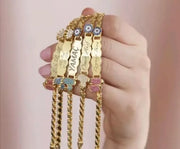Welcome your little one with the Personalized Name Bracelet for Newborn - CZ Customizations from Sairahaz Jewelers. holding on hand